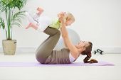 picture of infants  - Healthy mother and baby making gymnastics at room - JPG 
