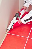 stock photo of silicon  - Worker Applies Silicone Sealant On Corner Wall Tiles - JPG 