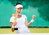 foto of sports  - Pretty tennis player won the cup at the sport competition - JPG 