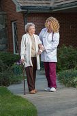 image of outdoor  - Nurse Helping Senior Walking with Cane Outdoor in Early Morning Outside House - JPG 