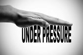 picture of pressure  - a man hand in black and white pressing the sentence under pressure written in black - JPG 