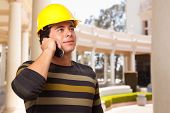 image of construction worker  - Handsome Hispanic Contractor with Hard Hat Talking on His Cell Phone - JPG 