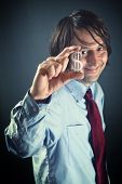 image of currency  - Bank officer in blue shirt holding a small dollar currency symbol in his hand and smiling - JPG 