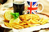 image of newspaper  - Traditional fish and chips with lemon and dark beer in newspaper wrapping - JPG 