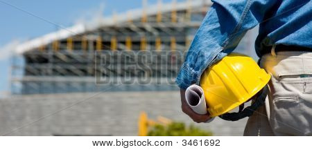 Picture or Photo of A construction worker or foreman at a construction site observing the progress of construction job or project with copy space