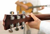 stock photo of objects  - Guitar lesson or two musicians playing together shot from behind one guitar with shallow focus - JPG 