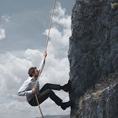 stock photo of business concept  - Chanllenge concept of a business man that climbs a mountain - JPG 