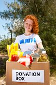 stock photo of food  - happy volunteer carrying food donation box - JPG 