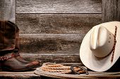 pic of cord  - American West rodeo traditional white straw cowboy hat with authentic Western lariat lasso and roper leather boots on distressed barn wood background - JPG 