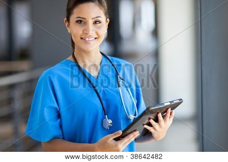 Picture or Photo of Beautiful young female medical intern with tablet computer in office