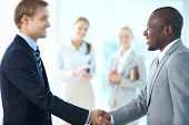 stock photo of handshake  - Portrait of happy leaders handshaking and two females applauding on background - JPG 