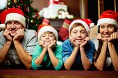 foto of brothers  - Portrait of friendly family in Santa caps looking at camera on Christmas evening - JPG 