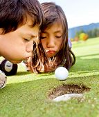 picture of golf  - Golf players cheating blowing to get the ball into the hole - JPG 