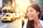 image of beams  - Asian woman Vivacious in New York City with a beautiful beaming smile backlit by the warm glow of the sun shining down a busy street with taxicabs in downtown Manhattan - JPG 