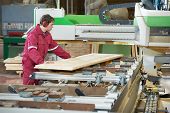 stock photo of beams  - Closeup process of carpenter worker with circular saw machine at wood beam cross cutting during furniture manufacture - JPG 