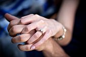 stock photo of close-up  - Close up of a young couples hands and diamond engagement ring with platinum and gold accents - JPG 