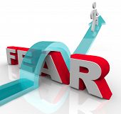stock photo of man  - A man jumps over the word fear on an arrow - JPG 