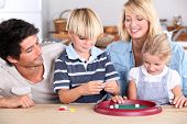 stock photo of game  - Family playing game at kitchen table - JPG 