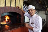 stock photo of restaurant  - portrait of chef cooking pizza at restaurant - JPG 