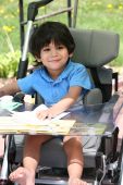 foto of cerebral  - Disabled little boy in medical stroller or wheelchair - JPG 