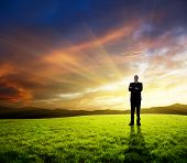 picture of leadership  - young businessman on green field and sunset - JPG 
