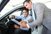 foto of transportation  - Car seller with car buyer looking at electronic tablet - JPG 