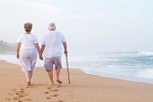 pic of beach  - senior couple hand in hand walking on beach - JPG 