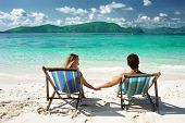 pic of beach  - Couple on a tropical beach in chaise lounge - JPG 