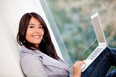 image of home  - Woman managing her online business at home and smiling - JPG 
