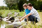 picture of animals  - Father and son playing near park lake - JPG 