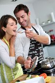 image of food  - Man preparing dinner and making her wife taste the food - JPG 