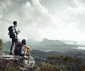 pic of valley  - Hikers with backpacks enjoying valley view from top of a mountain - JPG 