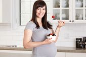 pic of home  - Pregnant woman eating a healthy snack at home in kitchen - JPG 