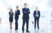image of leadership  - Portrait of young businessman looking at camera with elegant partners on background - JPG 