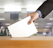 image of hand  - Hand putting a voting ballot in a slot of box - JPG 