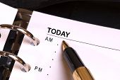 stock photo of yesterday  - open day planner with a gold fountain pen pointing to today - JPG 