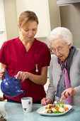image of home  - Senior woman with carer eating meal at home - JPG 