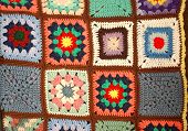 pic of section  - A vertically hung section of a crochet knit quilt showing squares with different colors and patterns - JPG 