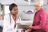 picture of health  - Doctor Discussing Records With Senior Female Patient - JPG 