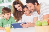 stock photo of family  - Family using a tablet pc in kitchen - JPG 