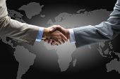 stock photo of handshake  - Handshake with map of the world in background - JPG 