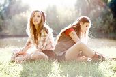 pic of outdoor  - two girlfriends outdoor sitting on grass back to back - JPG 