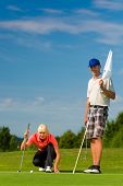 picture of golf  - Young female golf player on course putting - JPG 
