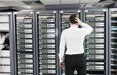 picture of isp  - it business man in network server room have problems and looking for  disaster situation  solution - JPG 