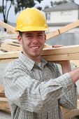 picture of construction worker  - A handsome construction man carrying some wood - JPG 