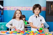 picture of kindergarten  - Portrait of cute friends playing with blocks at desk in kindergarten - JPG 