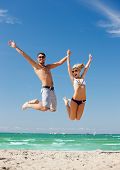 stock photo of beach  - picture of happy couple jumping on the beach - JPG 