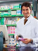 picture of scan  - portrait of mid adult pharmacist scanning medicine with barcode reader - JPG 