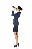 stock photo of future  - Businesswoman with binoculars searching for business oportunity in the future - JPG 
