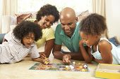 stock photo of game  - Family Playing Board Game At Home - JPG 